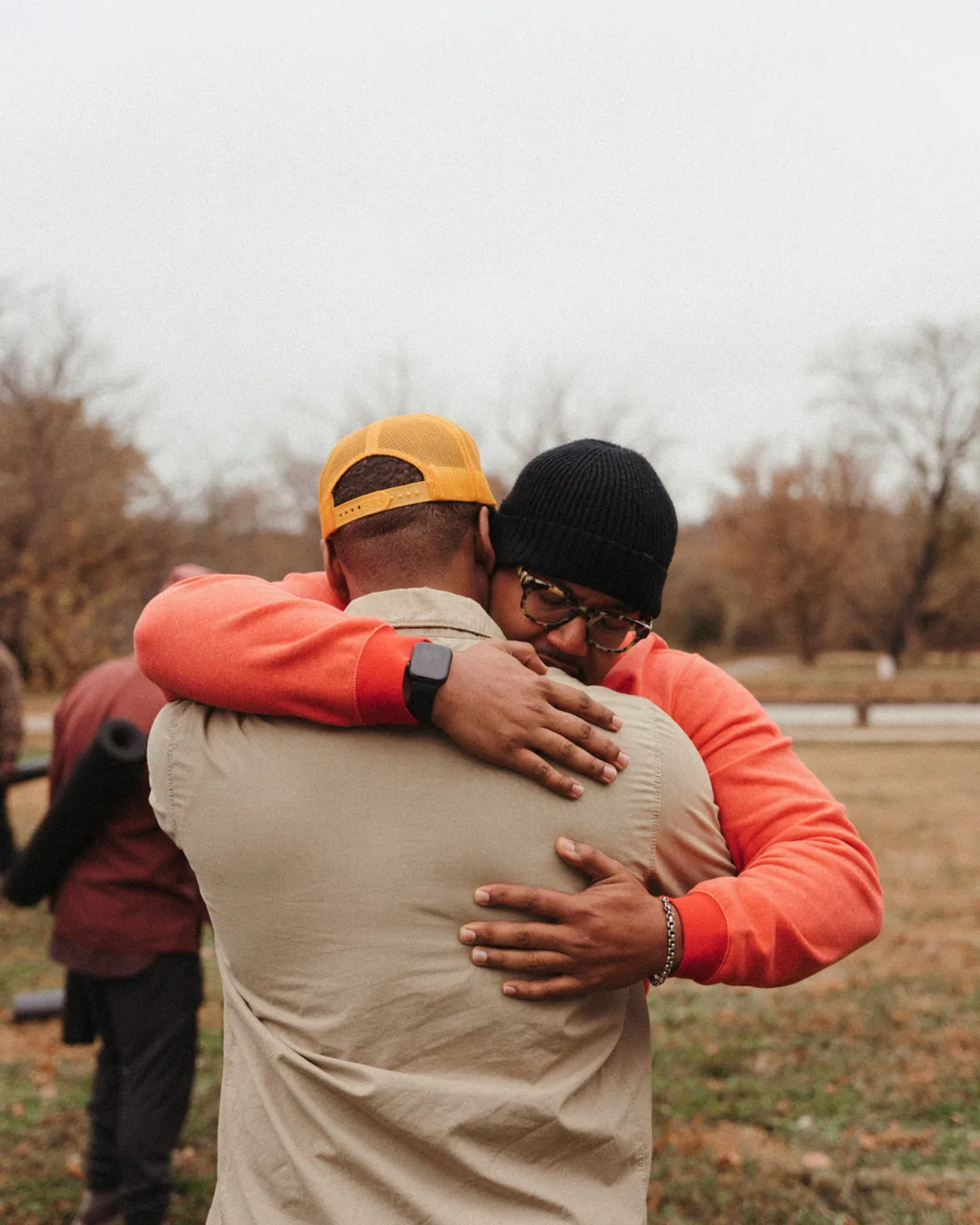 Two men embracing in an open field