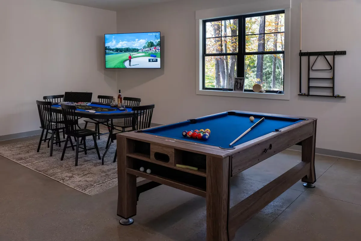 A games room with a pool table and shuffleboard