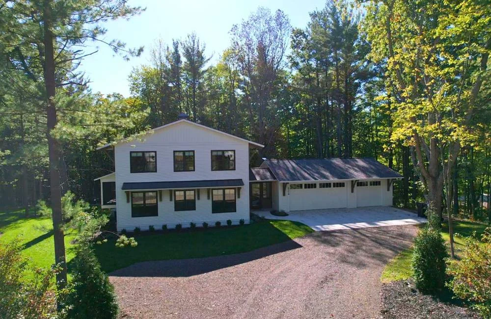 The Dutch seen from above, its gravel drive curving up past the garage through the pines