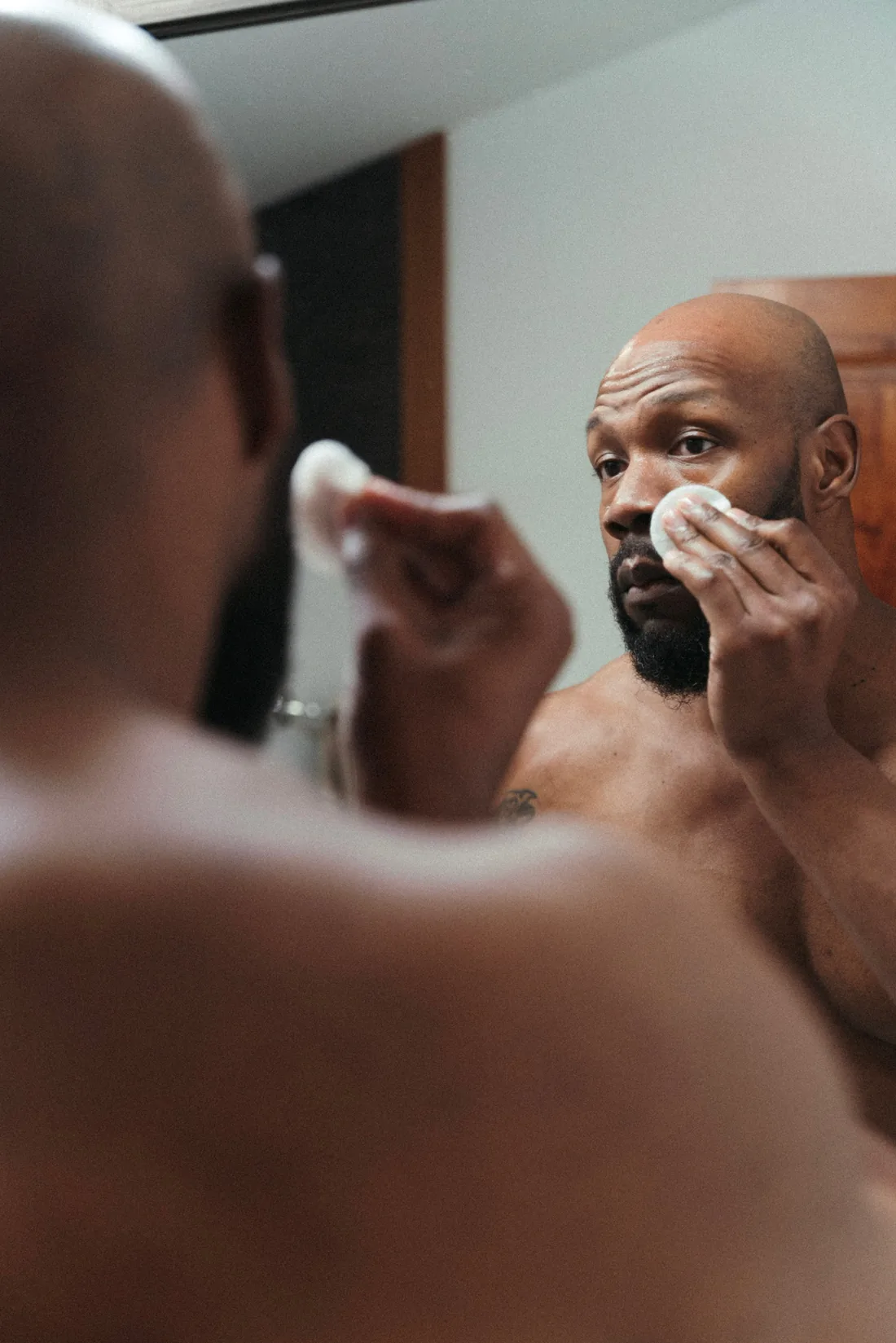 A man applying product at the bathroom mirror during a previous Healing retreat